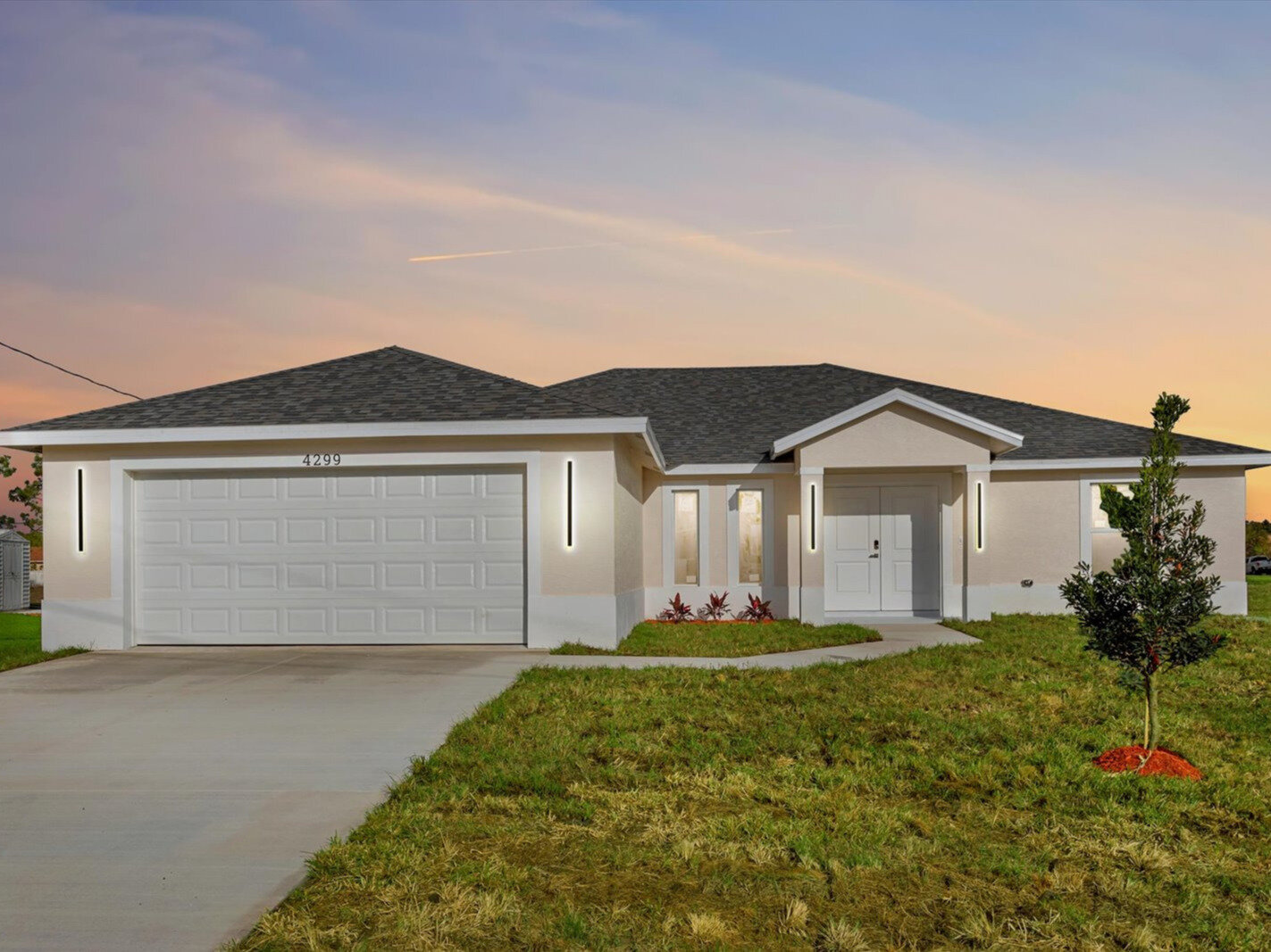 Completed MEF Homes single-family home with modern exterior lighting at twilight in Port St. Lucie, Florida